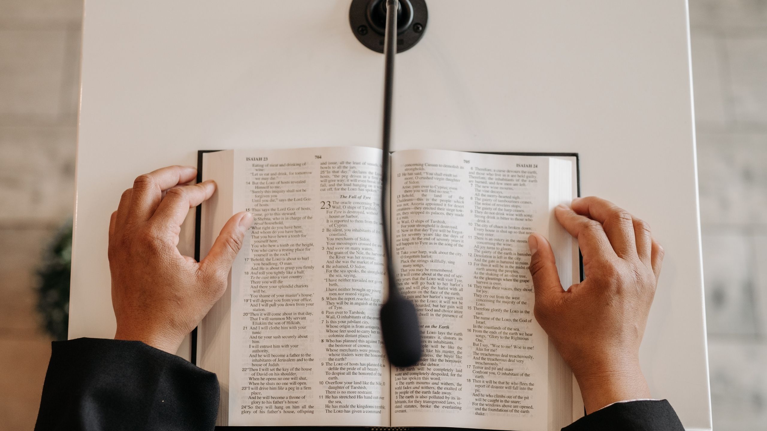 Pastor writing sermon notes beside an open Bible